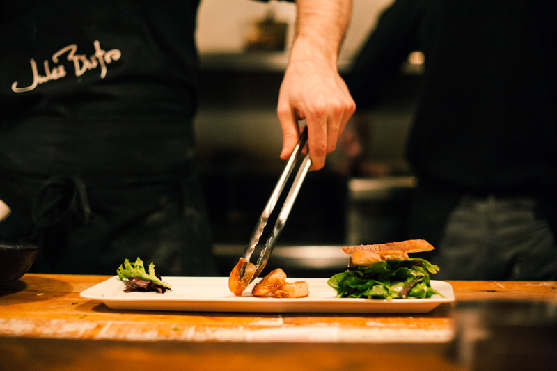 A person cutting food on top of a wooden board.